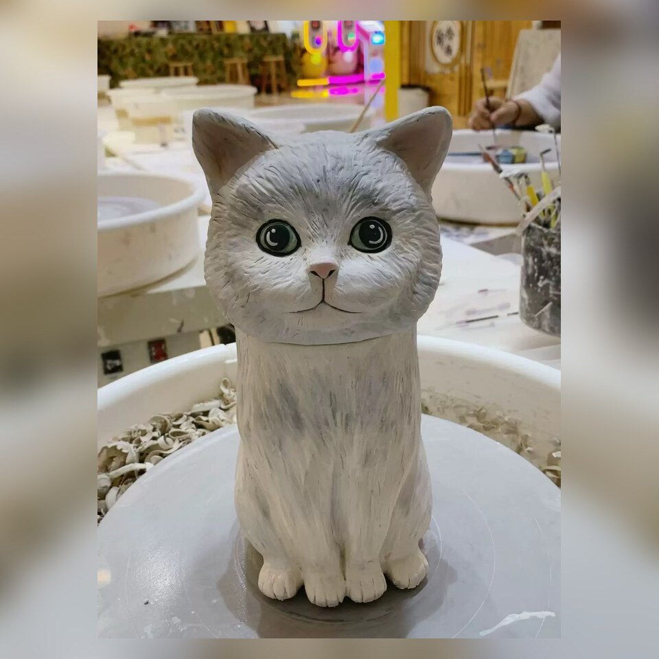 Hand-sculpted cat figurine being finished in the ceramics studio